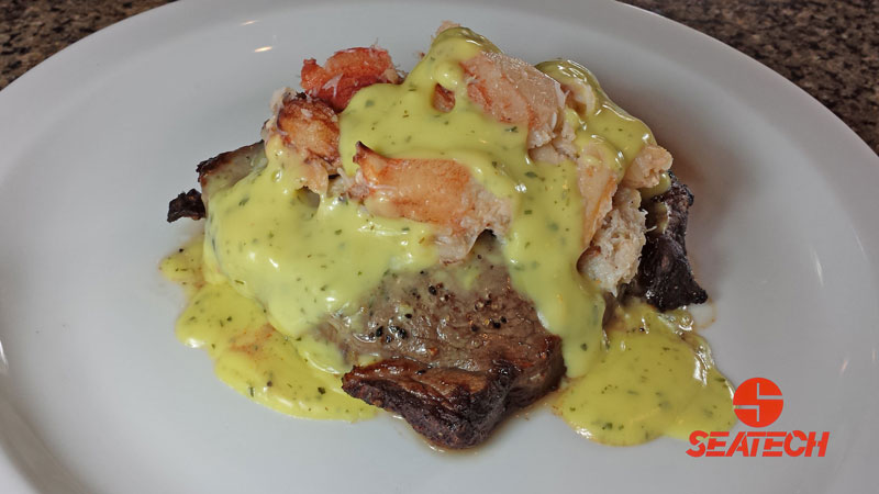 A photograph of Chilean crab meat steak oscar with a broiled steak topped with crab meat and bearnaise sauce.