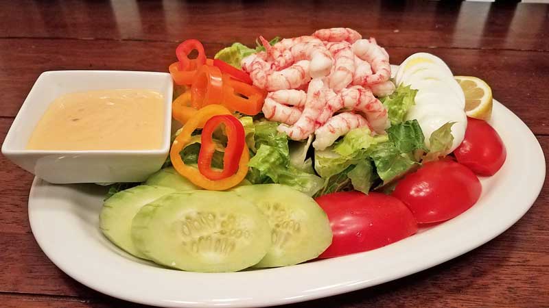 Seatech Chilean shrimp, lettuce, hard boiled egg, plum tomatos, cucumber slices, sweet peppers, lemon wedge and Louie dressing.