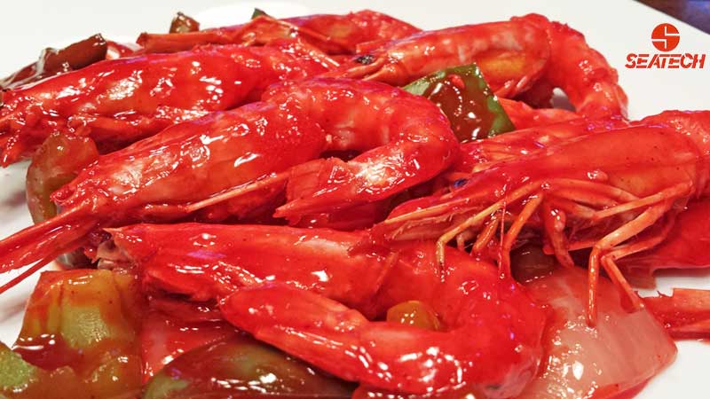 A photograph of sweet and sour Argentine shrimp with green bell pappers and onions